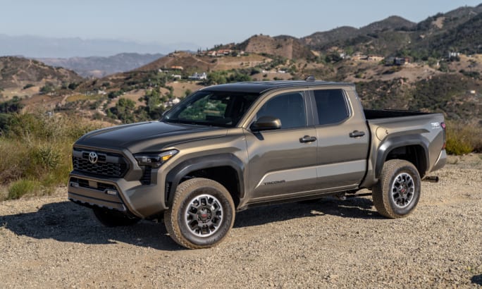 Bronze-colored Toyota four-door pickup truck parked in the desert in off road setting.