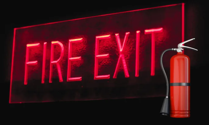 Red fire exit sign and fire extinguisher representing the critical role of emergency prep, evacuation readiness, and on-site fire protection for fleet facilities facing wildfire threats.