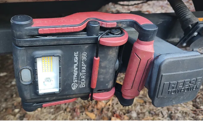 Photo of a work light magnetic mounted sideways to a trailer receiver hitch.