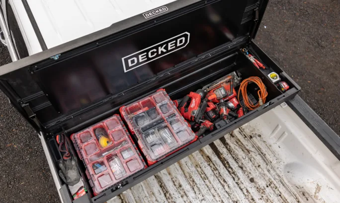 Top-down view of an open DECKED tool box showing organized tools and red cases stored inside.