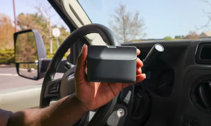Hand holding a Tag Pro device from DriveWell
