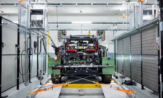 A vehicle test setup inside a lab facility, showing a partially assembled vehicle secured to testing equipment.
