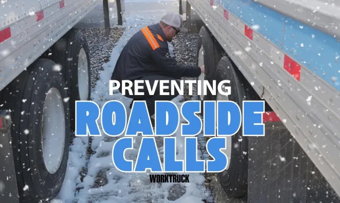 Technician checks semi-truck tire pressure in snowy yard between trailers to help prevent winter breakdowns and roadside calls.