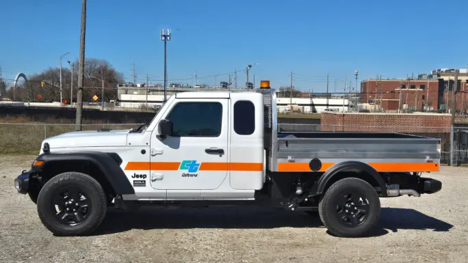 Front three-quarter view of the Acela Dispatcher 4x4 compact work truck with extended cab and aluminum flatbed, designed for fleet use in construction, utilities, and municipal operations.