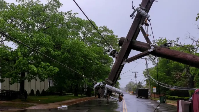 A downed power line during a storm on a suburban street.