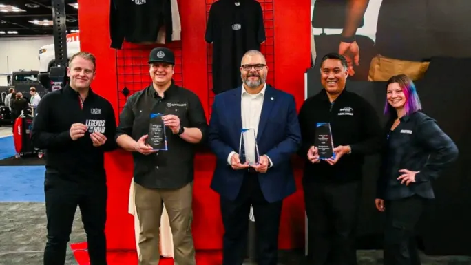 Upfit Package of the Year award winners hold trophies during Work Truck Week 2026 awards ceremony recognizing commercial vehicle equipment innovation.