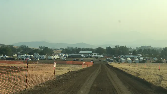 Wide view of emergency base camp with trailers and equipment, showing large-scale disaster response coordination