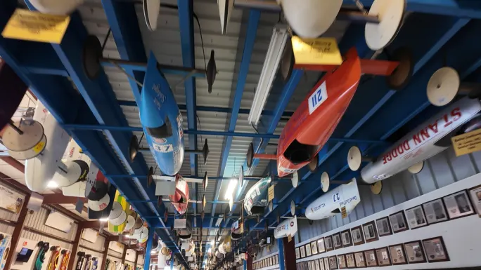 Rows of historic Soap Box Derby race cars suspended from the ceiling inside the Derby museum in Akron, Ohio.