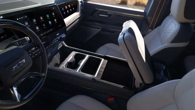 Interior of the 2027 Chevrolet Silverado 1500 showing the digital dashboard, front passenger display, and Multi-Flex center console folded into a workspace.