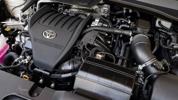 Engine compartment of a 2027 Toyota Grand Highlander showing the Toyota 2.4L turbocharged gas engine.