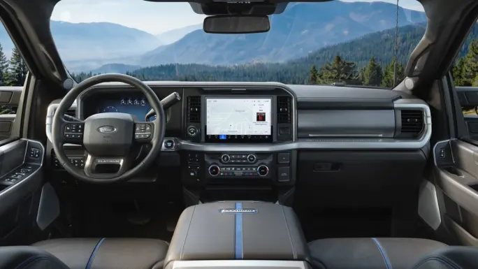 Ford Super Duty Platinum interior showing the steering wheel, instrument cluster, center touchscreen, climate controls, and front center console.