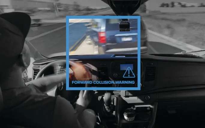A man driving in a car with a warning sign of forward collision
