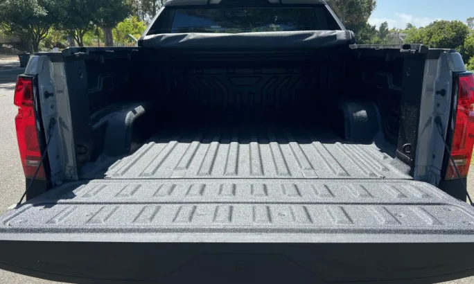 A rear view of the Silverado cargo bed with the tailgate lowered and tonneau cover rolled up.