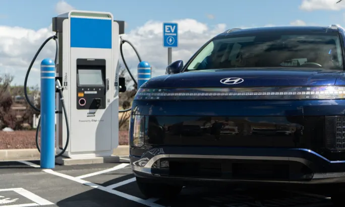 A Hyundai IONIQ 9 SUV parked next to an EV charger.