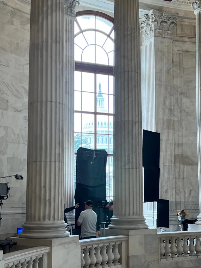 U.S. Capitol seen through a window bracketed by rotunda columns.