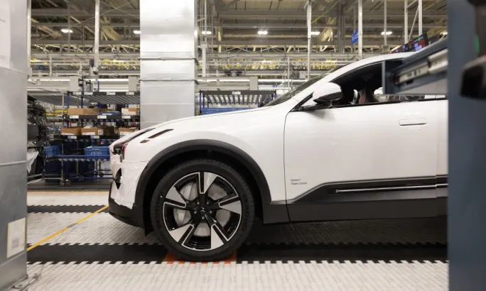 A side view of a white Polestar 3 in a manufacturing warehouse.