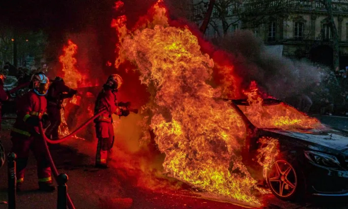 Firefighters extinguishing an auto blaze.