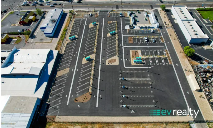 Overhead view of EV truck charging facility with organized lanes, charging stations, and parking areas for commercial fleet operations.