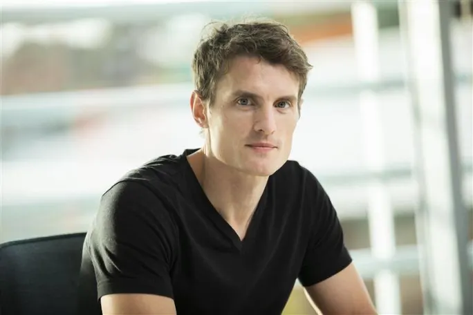 Photo of Gavin Sweeney in a black V-neck T-shirt.