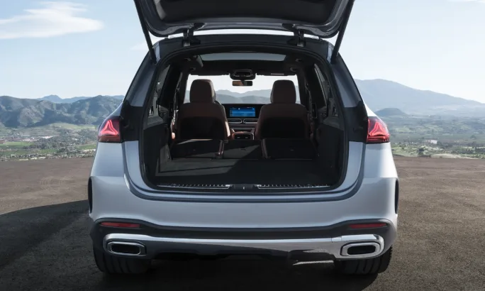 Rear cargo area of Mercedes-Benz GLE with liftgate open, showing spacious trunk and folded seating for increased storage capacity.