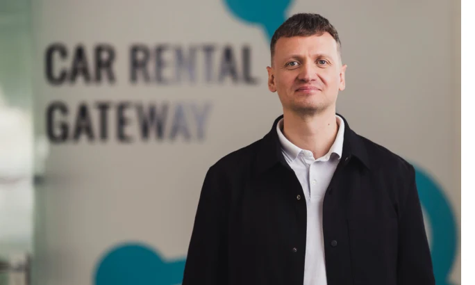 Hannes Poldvee in front of the Car Rental Gateway wall logo.