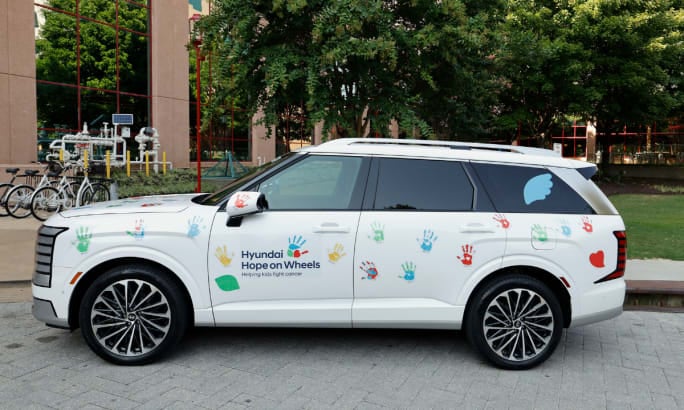 Hyundai vehicle decorated with colorful handprints for the Hyundai Hope on Wheels program, which supports pediatric cancer research and community outreach initiatives.