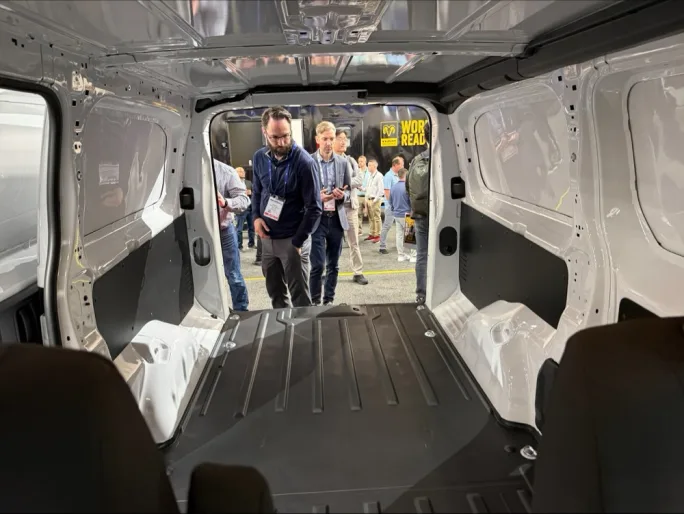 View from inside the cargo area of the 2027 Ram ProMaster City as attendees look inside at Work Truck Week 2026, highlighting the van’s flat load floor and commercial cargo space.