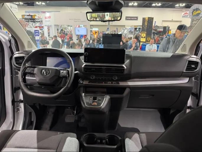 Interior dashboard and steering wheel of the 2027 Ram ProMaster City showing the digital instrument cluster, center touchscreen, and commercial van cockpit at Work Truck Week 2026.