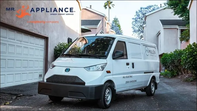 A Mullen Automotive van parked near houses.