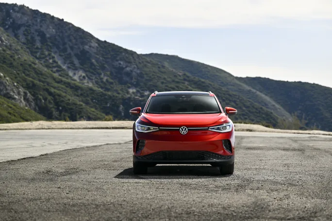 A red ID.4 SUV sits in front of mountains.