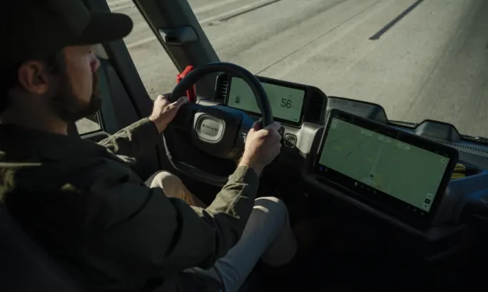 Front cab interior of the Rivian commercial van's driver seat, dashboard, and infotainment center.