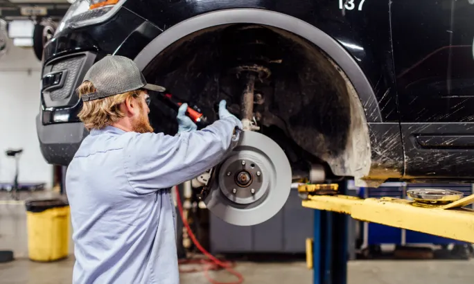 A technician working on a vehicle tire.