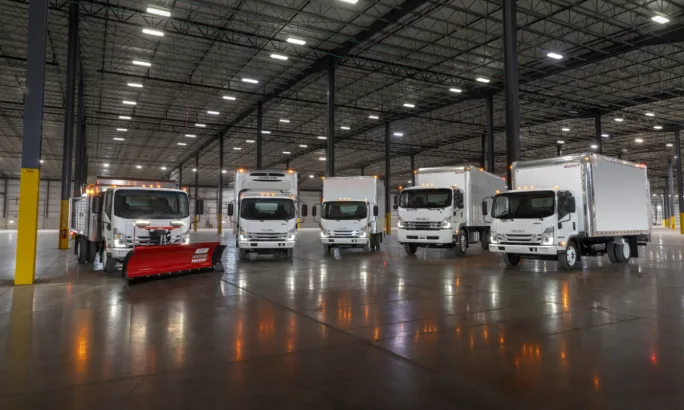 Lineup of Isuzu trucks in a warehouse.