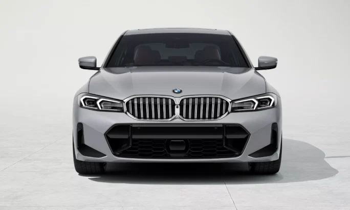 Front of a silver 2025 BMW 3 Series in a white showroom.