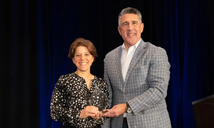 Woman receives award on stage. 