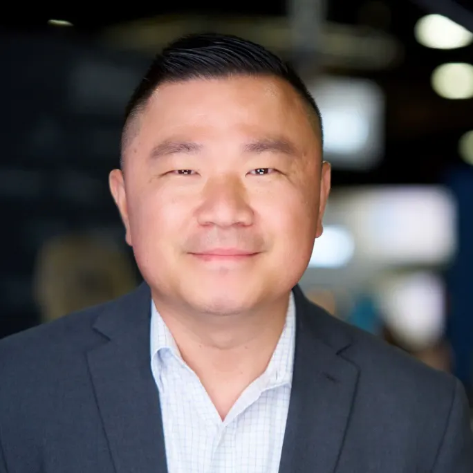 A business portrait of a man in a blue suit.