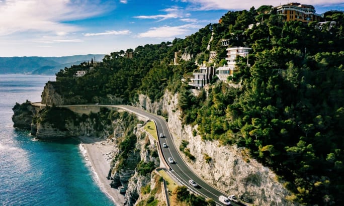 A scenic coastal road along a mountainous European island.