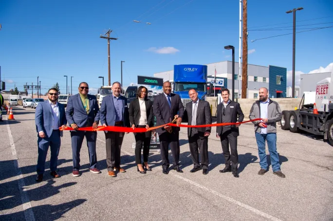 Dignitaries at a ribbon cutting for a new truck charging depot.