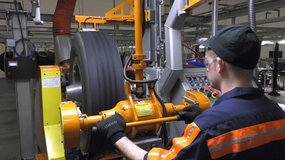 A technician on a tire buffing machine