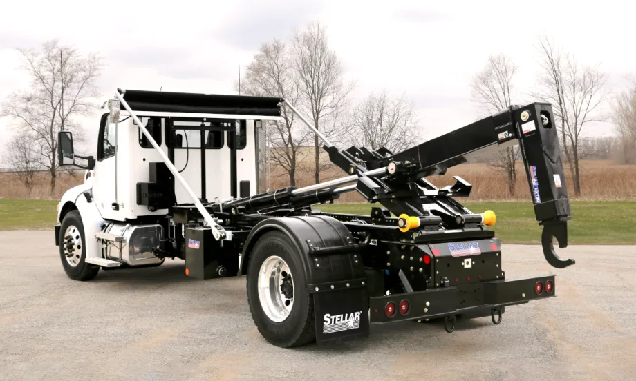 White cab hooklift truck parked facing away from the camera.