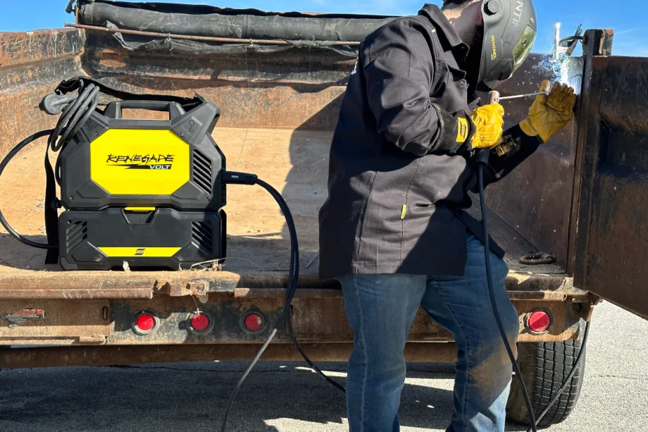 Man welding with the welding unit in the back of a work truck.