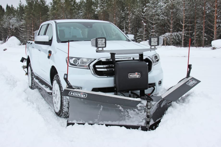 White truck with attached snow plow, ideal for winter maintenance.