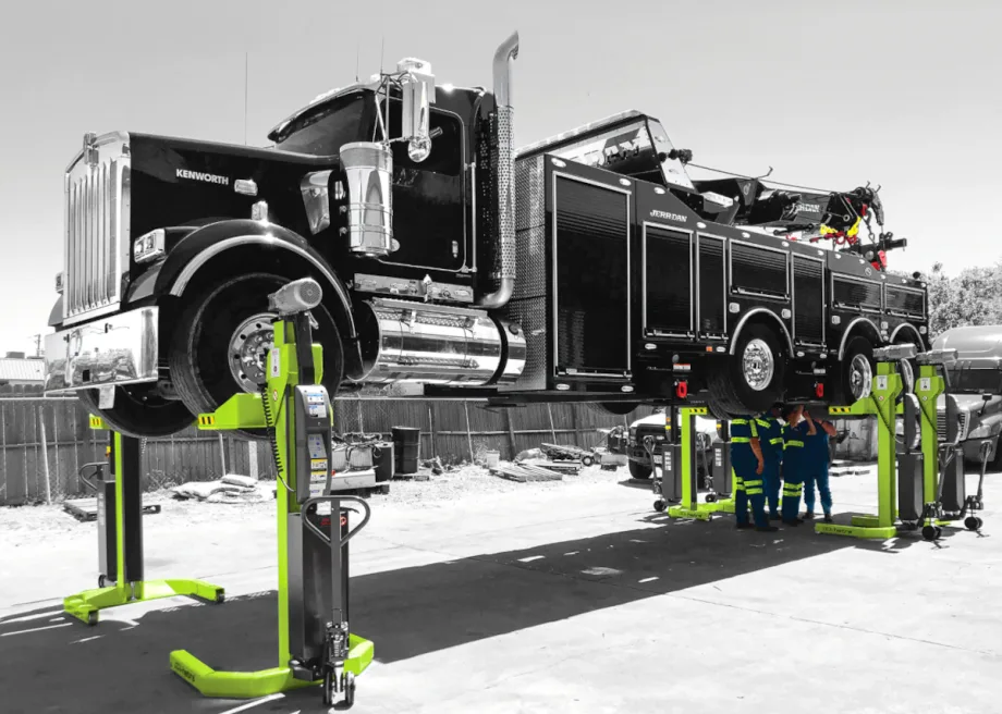 A large truck parked on a lift at a mechanic's garage.