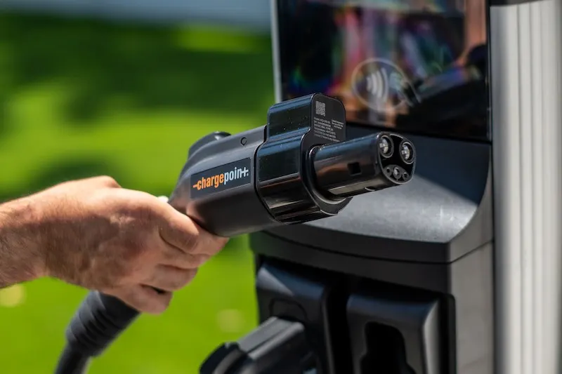 Hand gripping EV charger