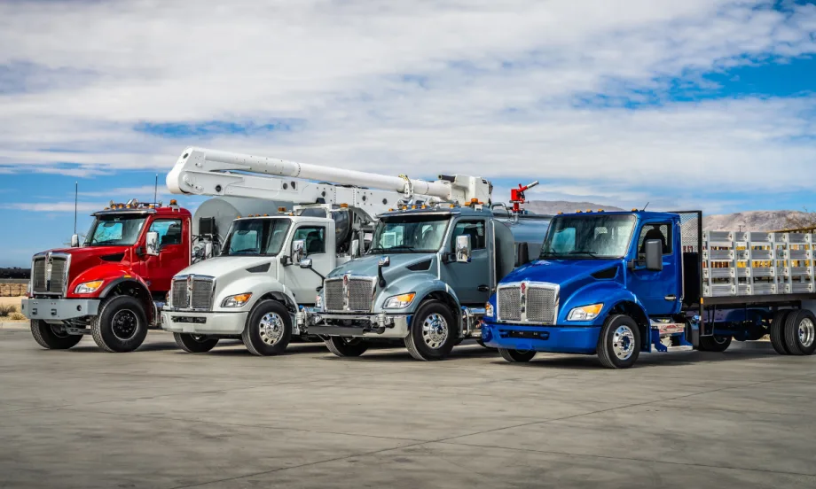 Photo of multiple medium-duty Kenworth trucks parked side by side.