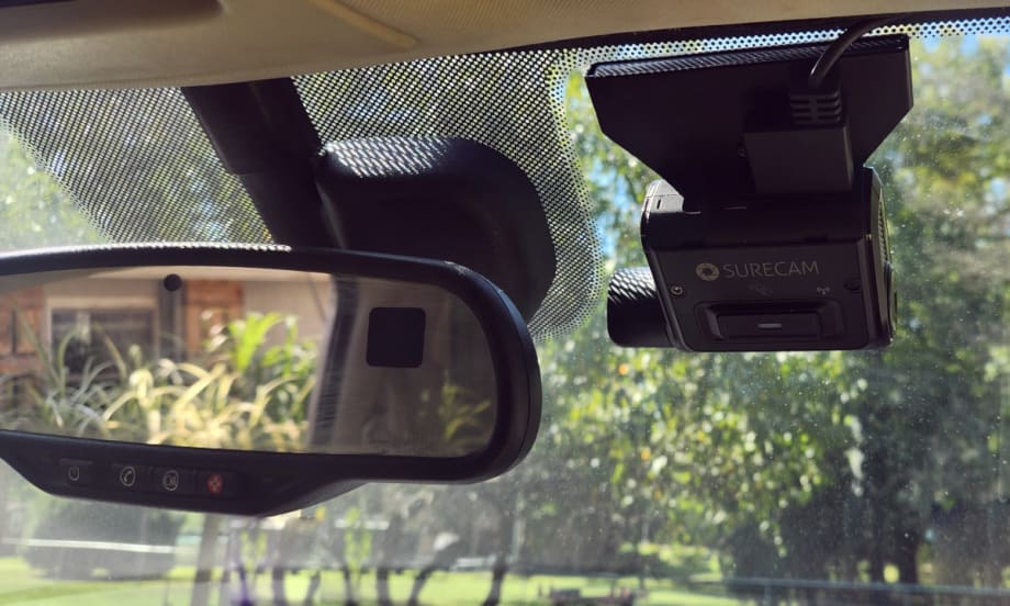 Photo of a dashcam mounted next to a rearview mirror.
