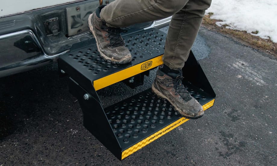 Person exiting the bed of a truck using a two-step platform installed in the receiver.