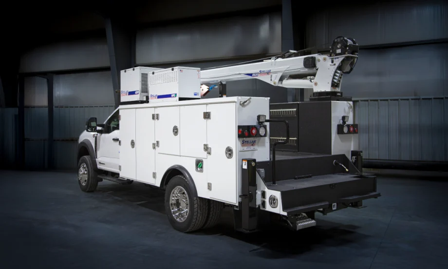 White service truck parked in a darkened industrial room.