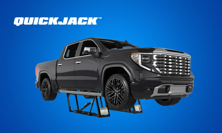 Black pickup truck on top of a car lift, against a blue background, inset white logo for QuickJack.