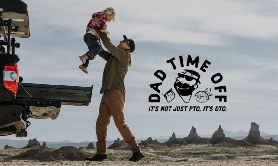 A dad lifts his child near a truck bed in a desert setting with the DECKED Dad Time Off logo and slogan: “It’s not just PTO, it’s DTO.”